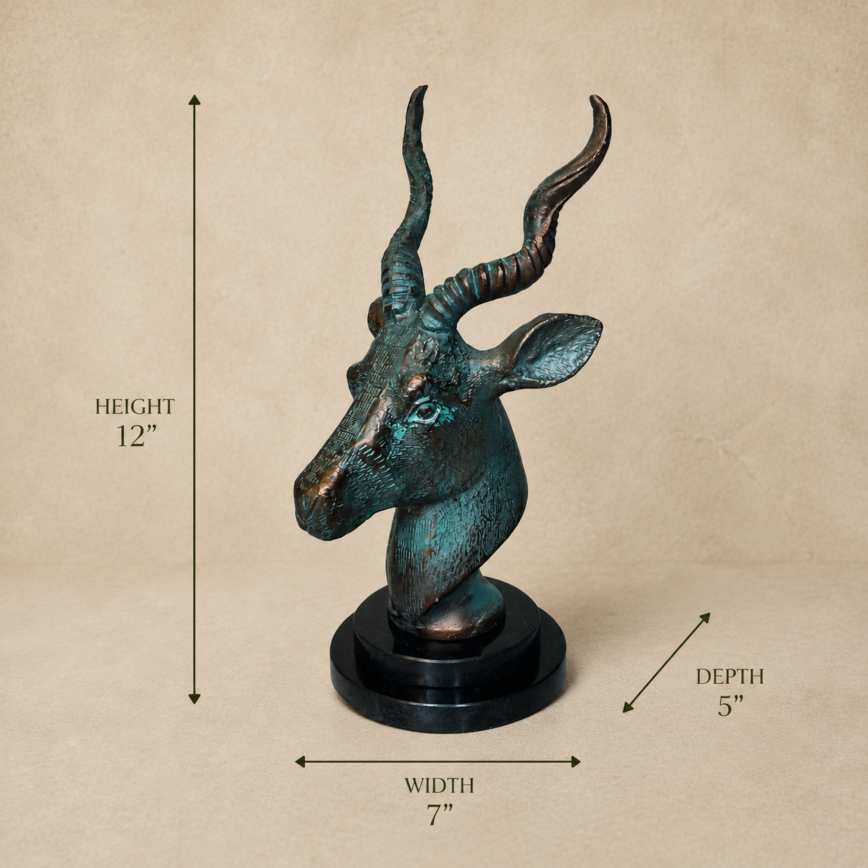 Antelope head sculpture with verdigris patina on a black base showing dimensions: 12 inches height, 7 inches width, and 5 inches depth against a luxury beige studio background.