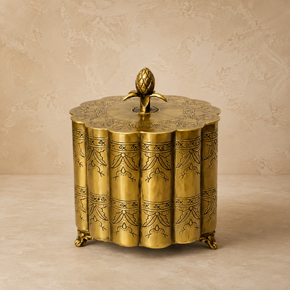 Antique brass scalloped decorative storage box with engraved detailing on a luxury beige Venetian plaster studio backdrop, premium vintage home decor accent.
