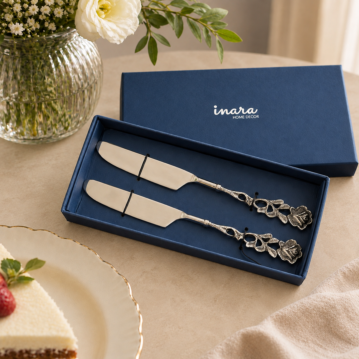 Antique Rose Cake Knife Set by Inara Home Decor displayed in a premium navy gift box on a warm beige Venetian seamless matte microcement tabletop with elegant floral décor, ideal for cake serving, gifting, weddings, and special occasions.