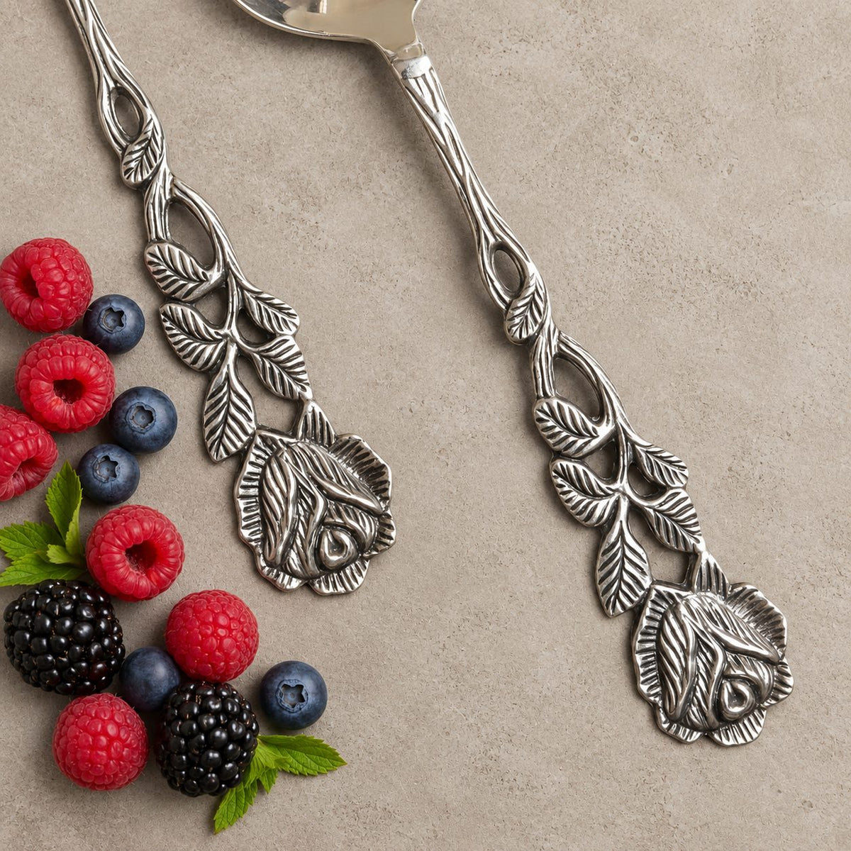 Detailed view of the handcrafted Antique Rose floral metal handles on the cake server and serving fork.