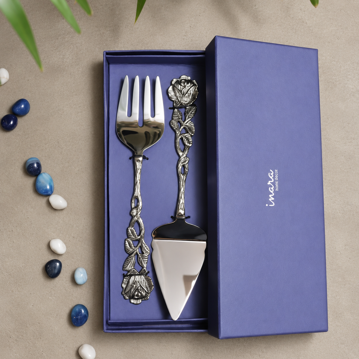 Antique Rose Cake Server and Fork Gift Set with handcrafted floral metal handles displayed in a premium gift box on a seamless matte microcement background, luxury servingware by Inara Home Decor.