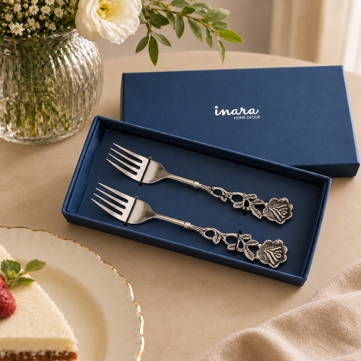 Luxury Antique Rose Dessert Forks Set of 2 by Inara Home Decor in a premium navy gift box on a warm beige Venetian seamless matte microcement surface with elegant floral styling.