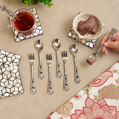 Antique Rose dessert spoons and forks set arranged with tea and chocolate dessert on a warm beige Venetian seamless matte microcement tabletop, luxury vintage servingware by Inara Home Decor.