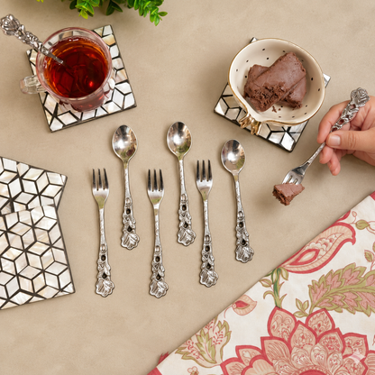 Antique Rose dessert spoons and forks set arranged with tea and chocolate dessert on a warm beige Venetian seamless matte microcement tabletop, luxury vintage servingware by Inara Home Decor.