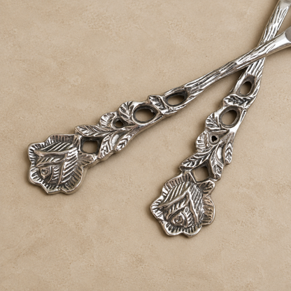 Close-up of Antique Rose Silver Coffee Spoons Set of 6 with ornate floral handles displayed on a warm beige Venetian seamless matte microcement surface, ideal for elegant tea and coffee serving.