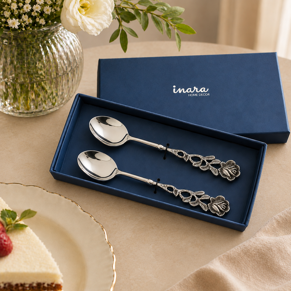 Antique Rose Silver Dessert Spoons Set of 2 in a luxury gift box by Inara Home Decor, featuring ornate floral handles on a warm beige seamless matte microcement surface, ideal for elegant dessert serving and gifting.