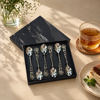 Antique silver floral coffee spoons set of 6 displayed in a luxury gift box on a warm beige Venetian seamless matte microcement surface with tea and dessert, premium serving cutlery by Inara Home Decor.
