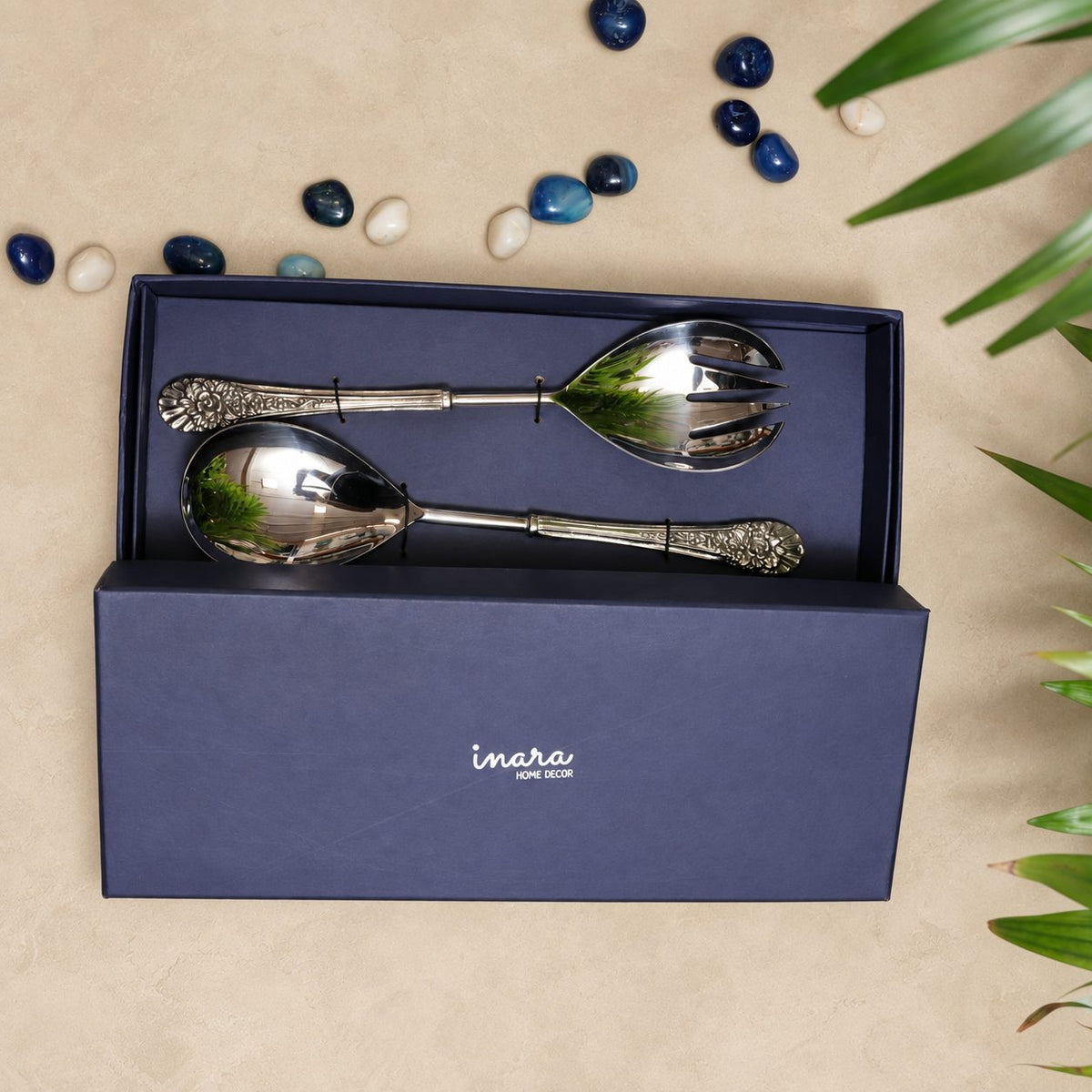 Antique silver salad serving spoon and fork set in a premium Inara Home Decor gift box on a warm beige Venetian seamless matte microcement surface, featuring ornate floral handles and elegant flat lay styling.