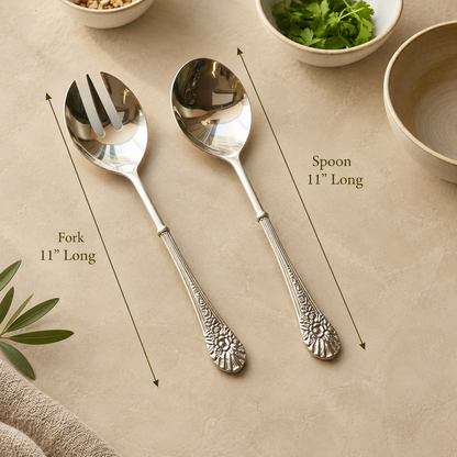 Antique silver serving spoon and fork set with ornate floral handles, each measuring 11 inches long, displayed on a warm beige Venetian seamless matte microcement surface with elegant olive green dimension arrows. Perfect for luxury table settings and servingware by Inara Home Decor.