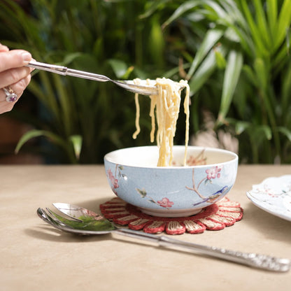 Antique Silver Serving Spoon and Fork Set with noodle bowl on a warm beige Venetian seamless matte microcement tabletop, luxury stainless steel servingware by Inara Home Decor.