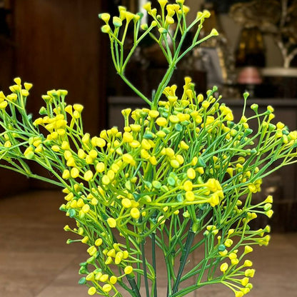 Close-up of a realistic artificial yellow berry beads bunch with flexible green stems made from premium PU.