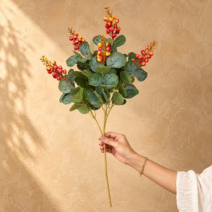 Hand holding a 31-inch artificial berry eucalyptus stem with realistic foliage and vibrant berry clusters for size reference.
