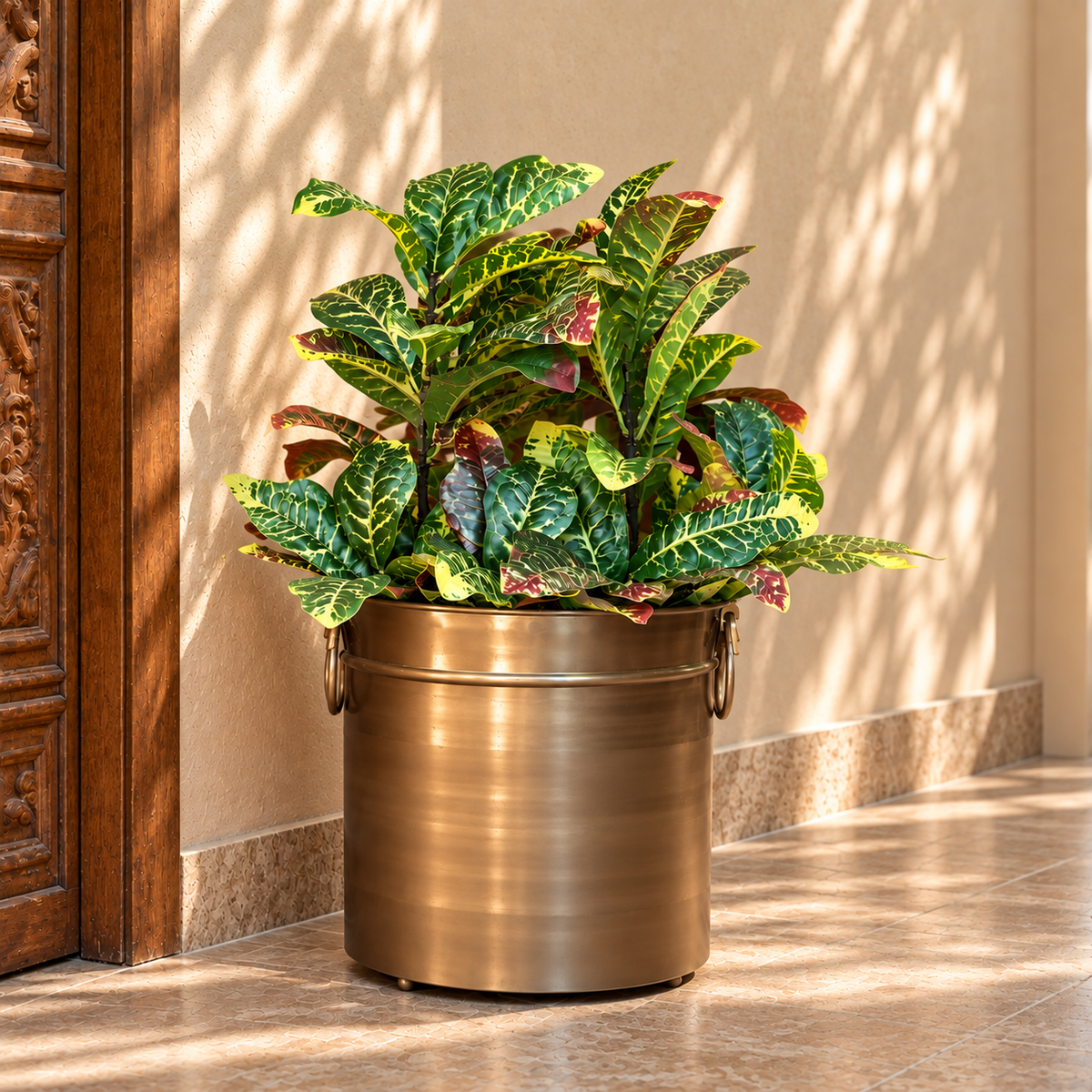 Artificial Croton foliage bunch with realistic variegated green, yellow and burgundy leaves styled in a brass planter for elegant home décor.