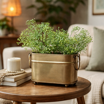 Artificial green baby's breath stems styled in a brass planter for elegant living room and tabletop décor.