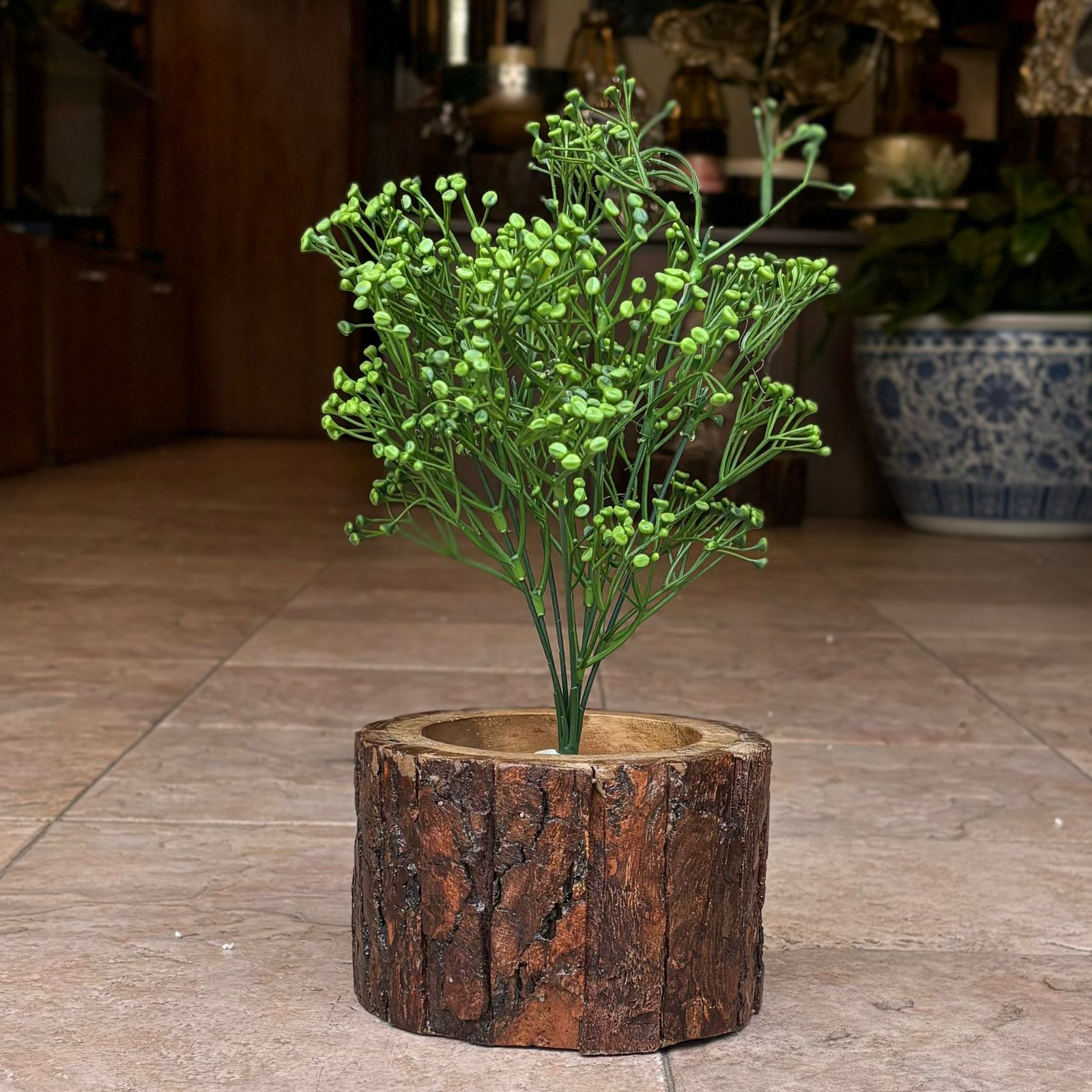 Artificial green baby's breath stem displayed in a rustic wooden planter, adding natural-looking greenery to home décor.