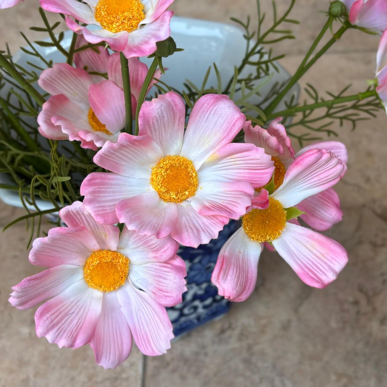 Close-up of real-touch artificial pink cosmos flowers with soft white petals and vibrant yellow centers.