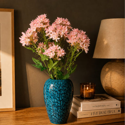 Artificial Pink Star Cluster Stem arranged in a blue textured glass vase on a wooden console table, creating an elegant luxury home décor display with soft pink blooms.