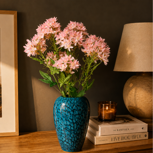 Artificial Pink Star Cluster Stem arranged in a blue textured glass vase on a wooden console table, creating an elegant luxury home décor display with soft pink blooms.