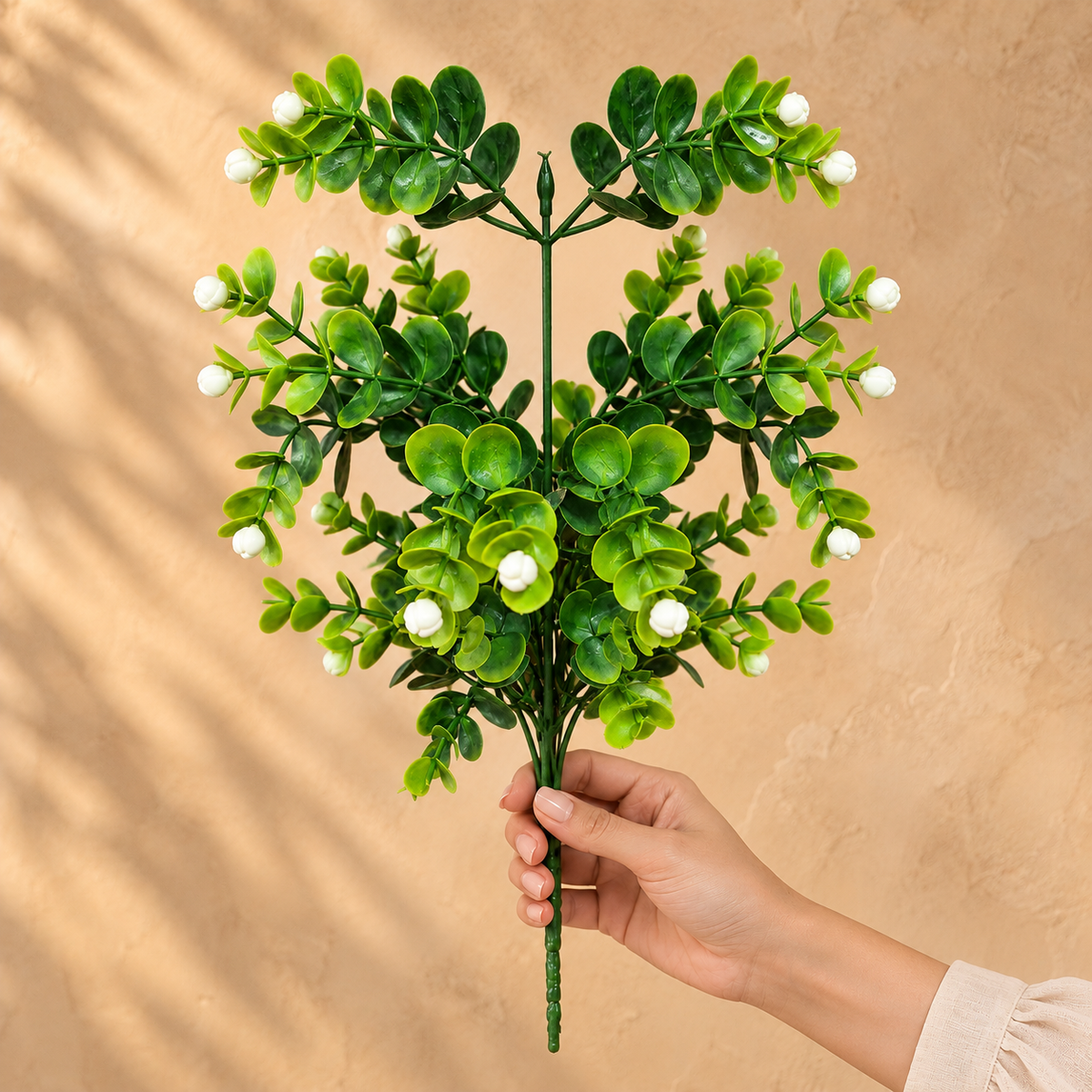13-inch artificial white berry eucalyptus foliage bunch with realistic green leaves displayed in hand for size reference.