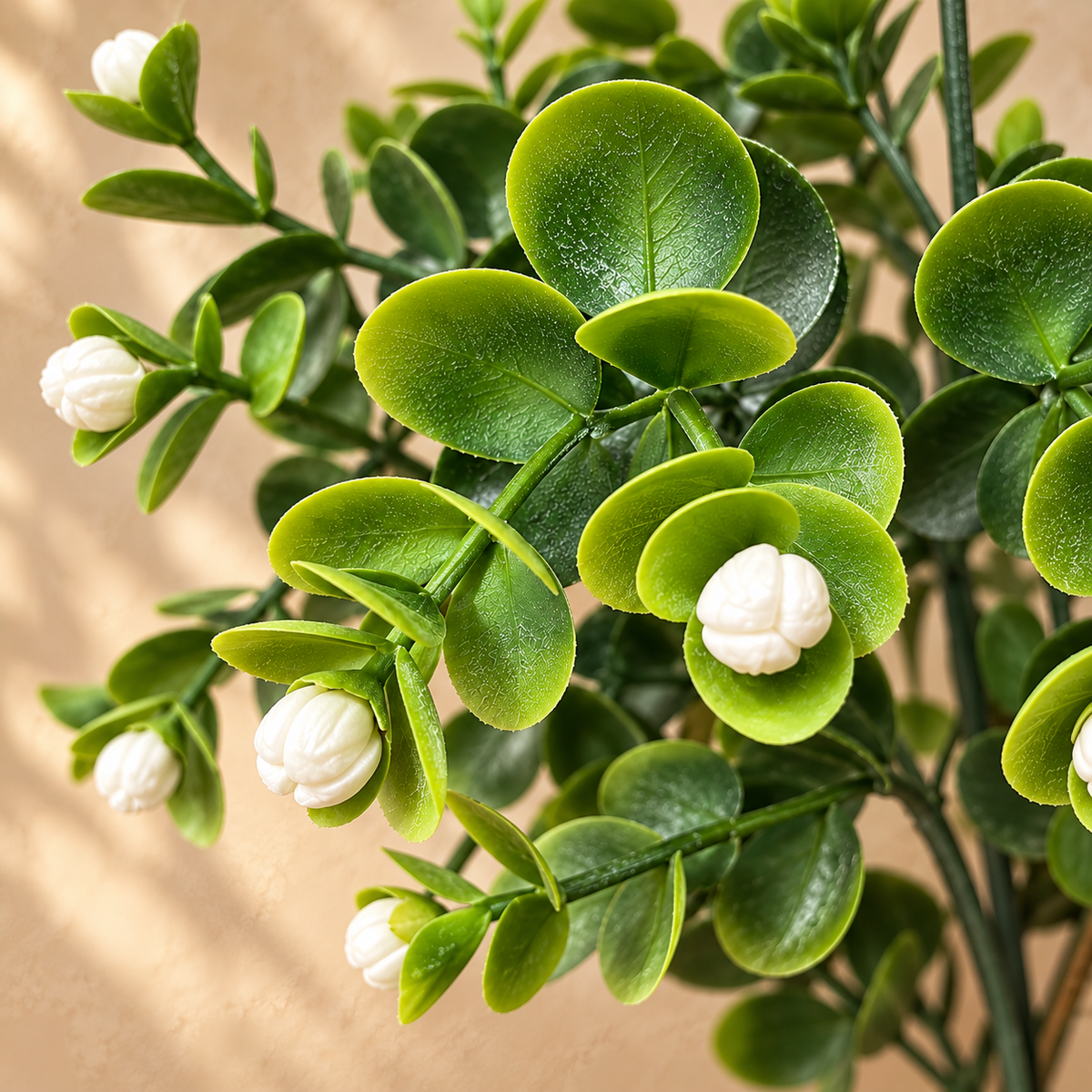 Close-up of artificial eucalyptus foliage with realistic green leaves and white berry buds showcasing lifelike detailing.
