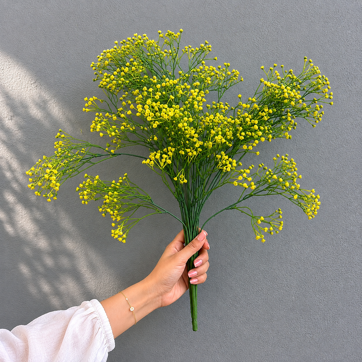 Hand holding an Artificial Yellow Berry Beads Bunch to show its size and realistic design, ideal for vases, centerpieces, and home décor displays.