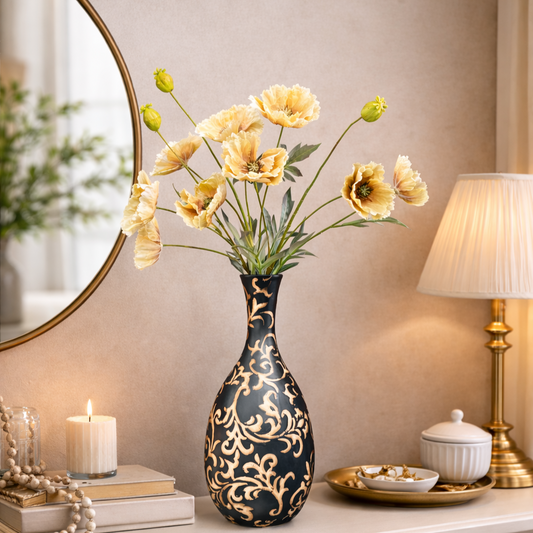 Black and gold floral decorative vase with yellow artificial flowers styled on a modern console table, luxury home décor setup with candle, mirror, and warm ambient lighting.