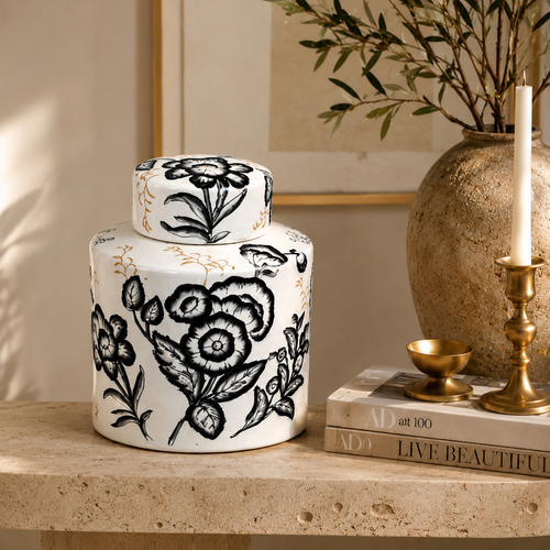 Hand-painted black and white ceramic ginger jar styled on a travertine console table with books and brass décor for elegant living room styling.