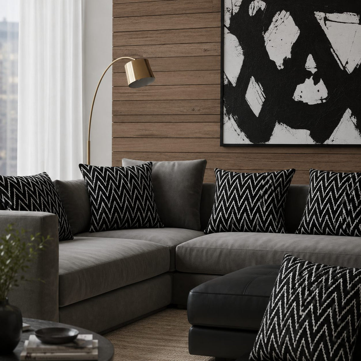 Black Zig Zag Velvet Cushion Covers styled on a modern grey sectional sofa in a contemporary living room with wood panel walls and abstract artwork, showcasing the textured woven pattern and luxury home décor appeal.