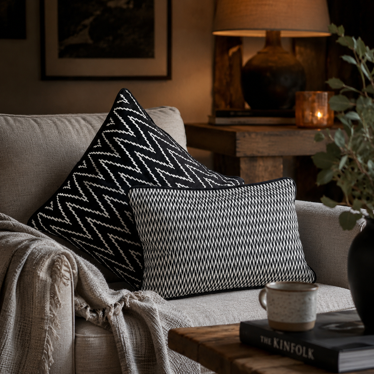 Black and white designer cushion covers styled on a beige armchair in a modern living room, featuring geometric patterns and premium decorative accents by Inara Home Decor.