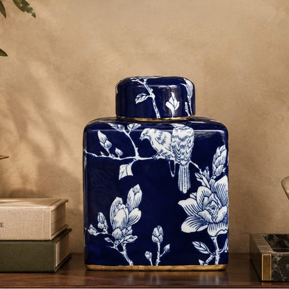 Elegant blue and white ceramic ginger jar displayed on a wooden console with candle, books, and classical sculpture in a luxury interior.