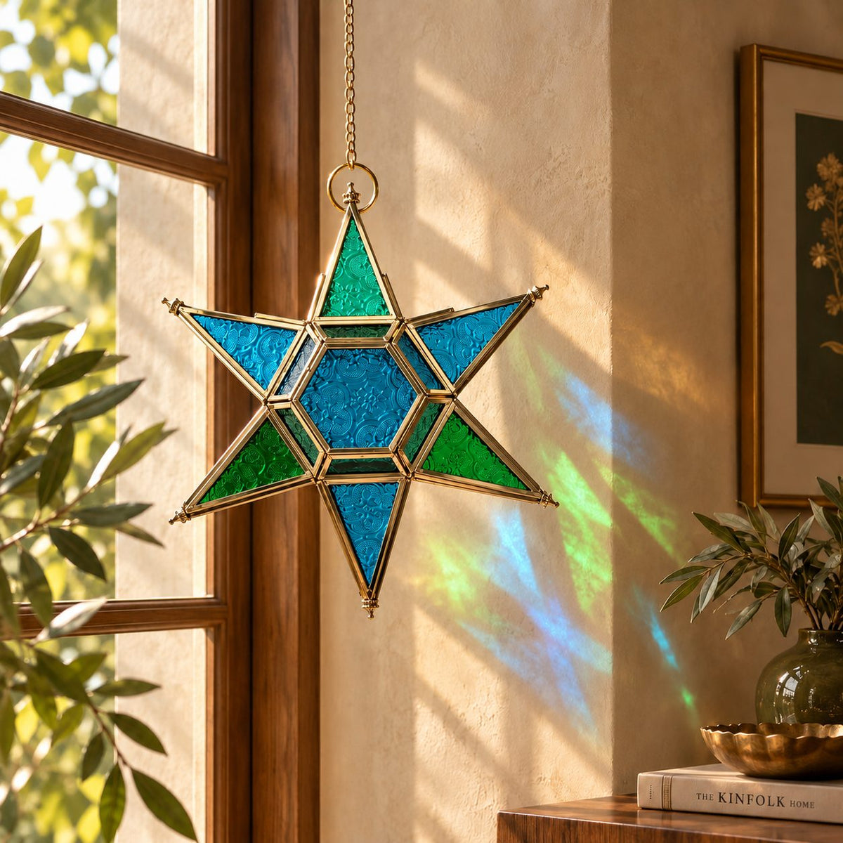 Blue and green stained glass hanging star lantern suspended near a window, casting colorful reflections for luxury indoor home décor.