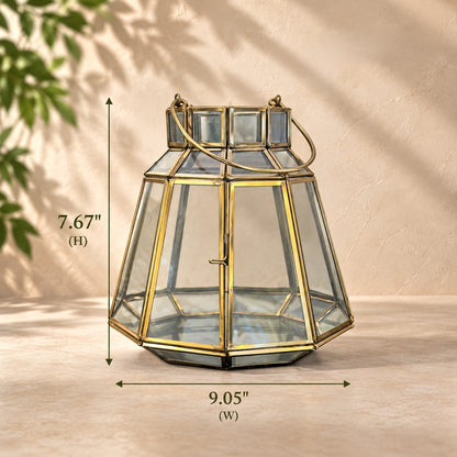 Handcrafted brass and clear glass geometric lantern with dimensions displayed, measuring 7.67 inches in height and 9.05 inches in width, suitable for indoor and sheltered outdoor décor.