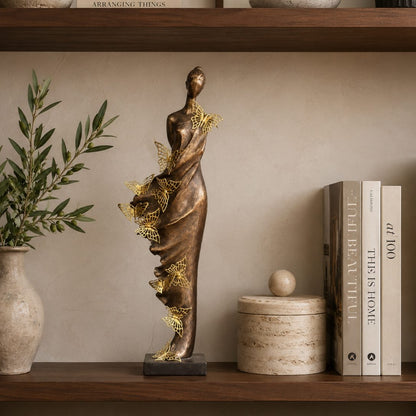 Butterfly Lady decorative sculpture styled on a luxury wooden bookshelf with books, ceramic décor, and olive branches in a contemporary interior.