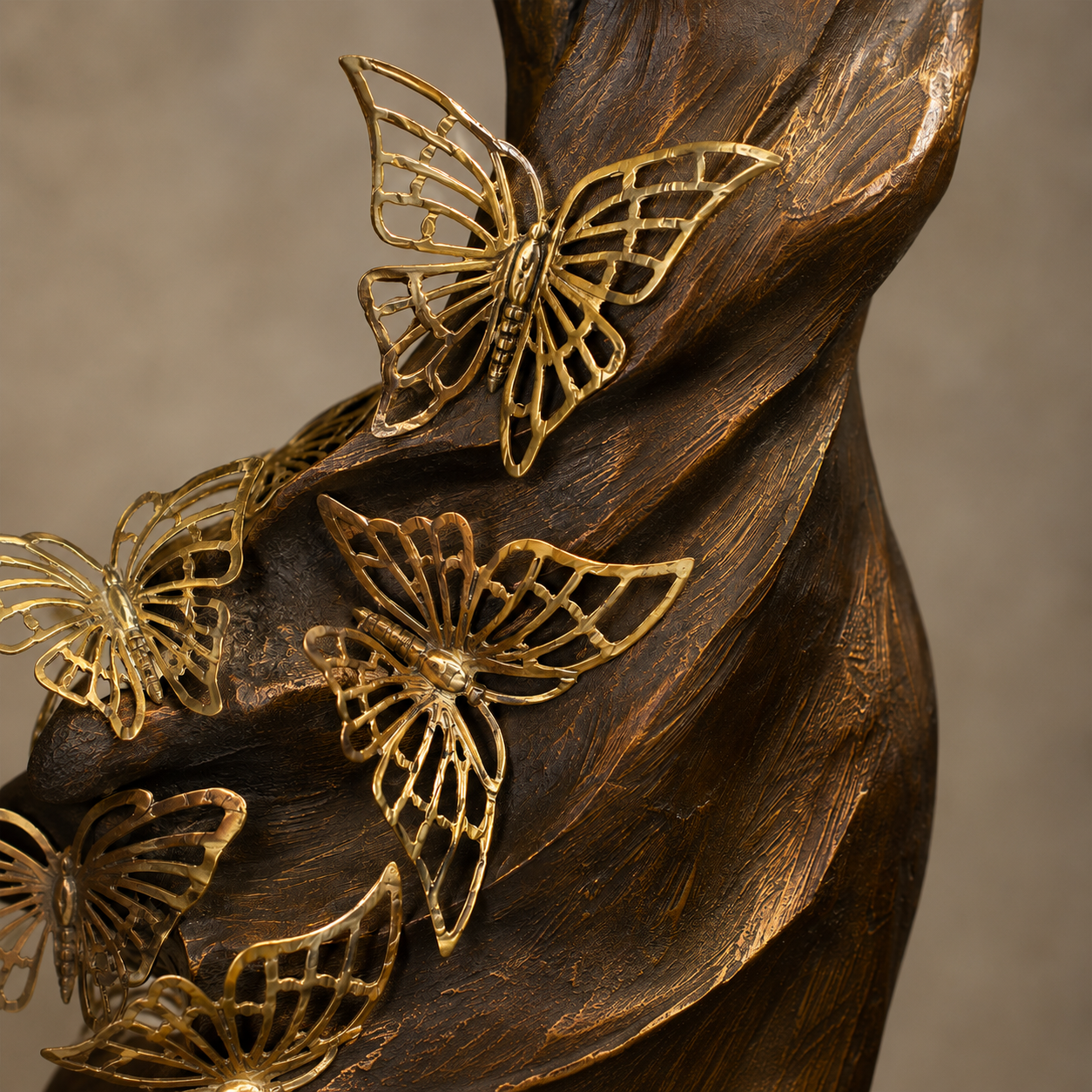 Close-up of the Butterfly Lady decorative sculpture showcasing intricate gold butterfly details and textured antique bronze finish.