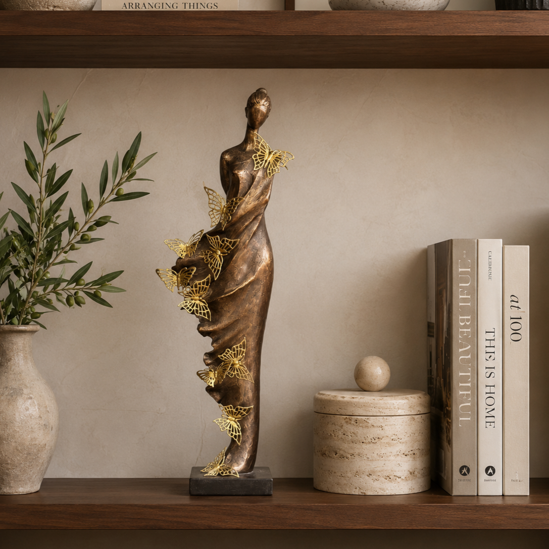 Butterfly Lady decorative sculpture styled on a luxury wooden bookshelf with books, ceramic décor, and olive branches in a contemporary interior.
