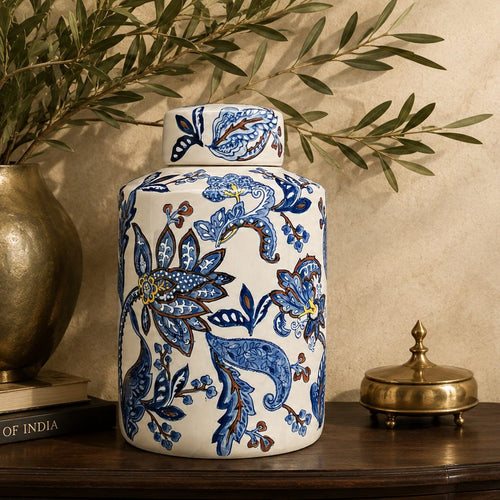 Luxury blue and white hand-painted ceramic decorative jar styled with olive branches and brass décor on a wooden console table.