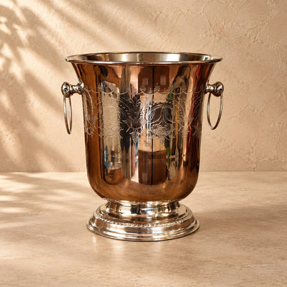 Classic stainless steel wine and champagne chiller with an engraved decorative finish on a premium luxury studio backdrop featuring a warm beige Venetian plaster wall and seamless matte microcement floor. Perfect for elegant home bars, dining tables, and luxury entertaining.