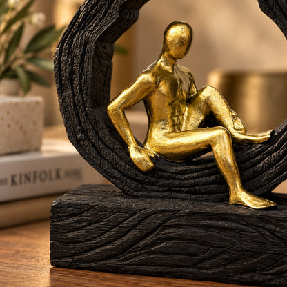 Close-up view of a premium resin sculpture showcasing the textured black frame and metallic gold seated figure with fine craftsmanship.