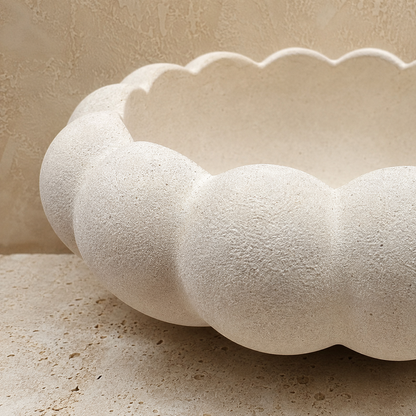 Close-up of a handcrafted white ceramic decorative bowl showcasing its elegant scalloped design and textured matte finish.