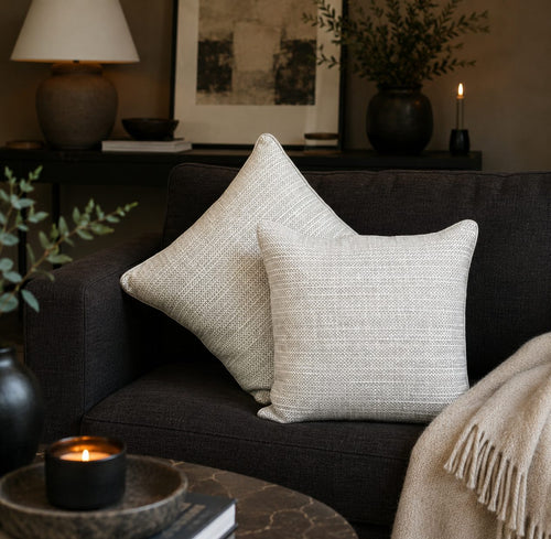 Premium beige striped linen cushion covers styled on a dark sofa in a modern living room, adding elegant texture and timeless luxury to contemporary home décor by Inara Home Decor.