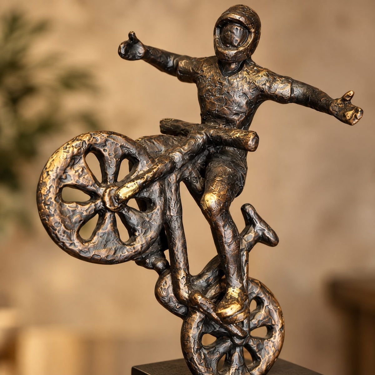 Close-up of premium resin cyclist balancing bike sculpture showcasing artistic craftsmanship, textured antique bronze finish and modern decorative design.