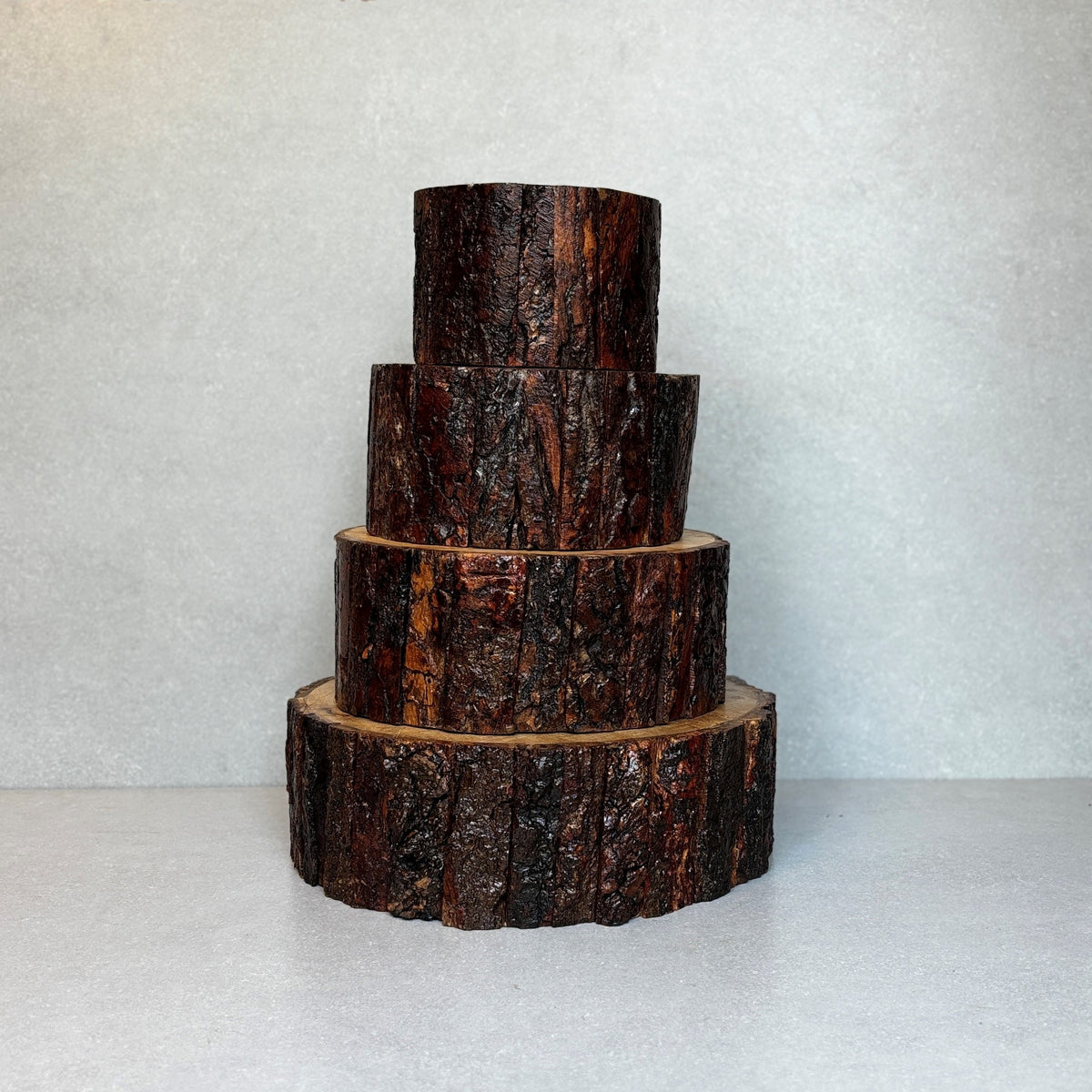 Set of four handcrafted natural wood bark bases with authentic bark texture, ideal as rustic display stands, risers, candle holders, or decorative home décor accents.