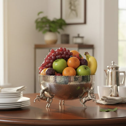 Luxury equestrian-style hammered metal bowl serving as a fruit or salad centerpiece, featuring ornate horse-shaped legs and a beaded rim.