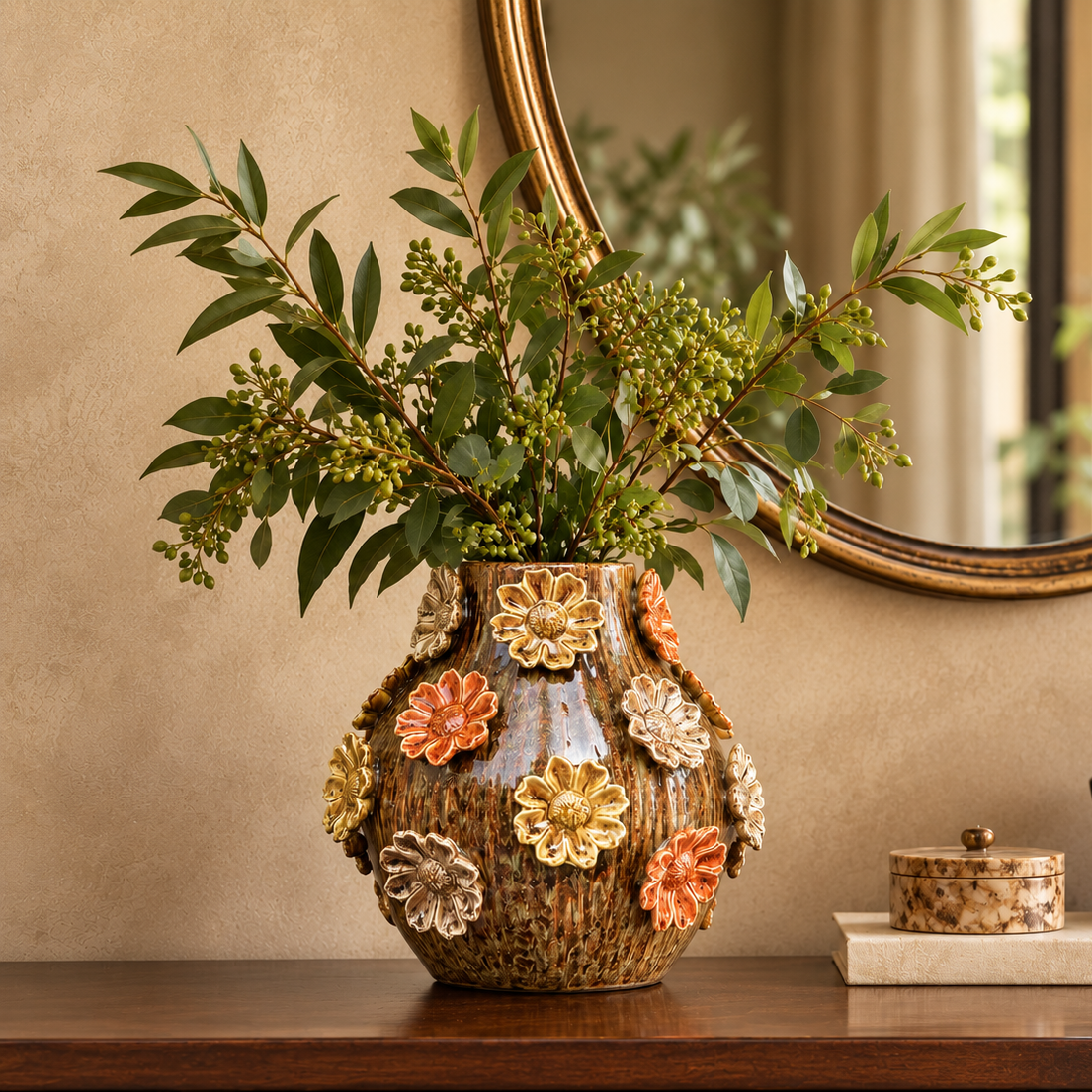 Handcrafted floral ceramic vase with green foliage styled on a wooden console