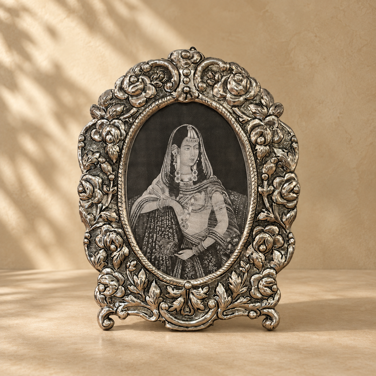 Florence Heirloom antique silver oval floral photo frame with intricate embossed detailing displayed against a warm neutral background.