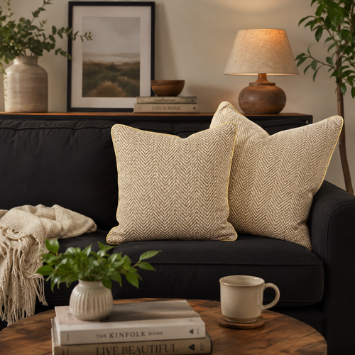 Beige herringbone cushion covers styled on a black sofa in a modern living room, featuring premium textured fabric and elegant neutral décor by Inara Home Decor.
