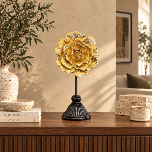 Elegant gold flower sculpture displayed on a walnut console table in a contemporary luxury living room with warm neutral décor.