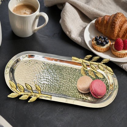 Elegant hammered silver serving tray with gold leaf handles styled with macarons, pastries, and coffee on a modern black tabletop, perfect for luxury dining, breakfast serving, and sophisticated home decor.