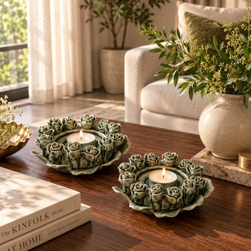 Green ceramic rose tealight holder with a lit tealight candle styled on a luxury wooden coffee table in a modern living room.