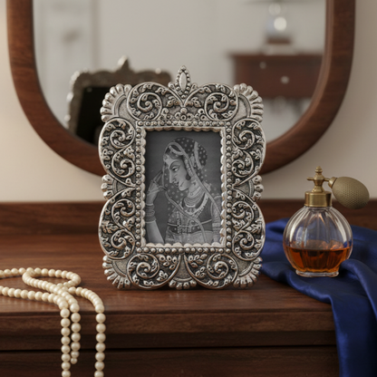 Handcrafted antique silver photo frame with intricate floral embossing placed on wooden dresser with vintage mirror and décor accents